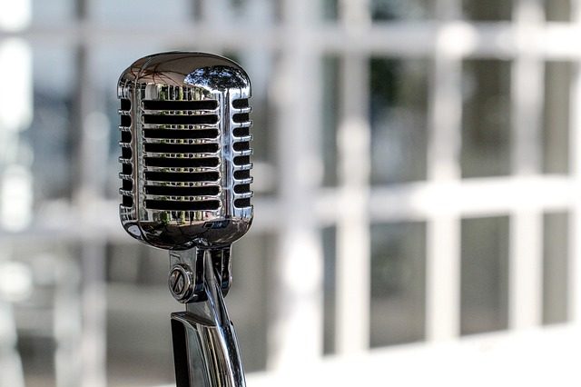 Vintage-style microphone with a glossy finish, set against a blurred background.